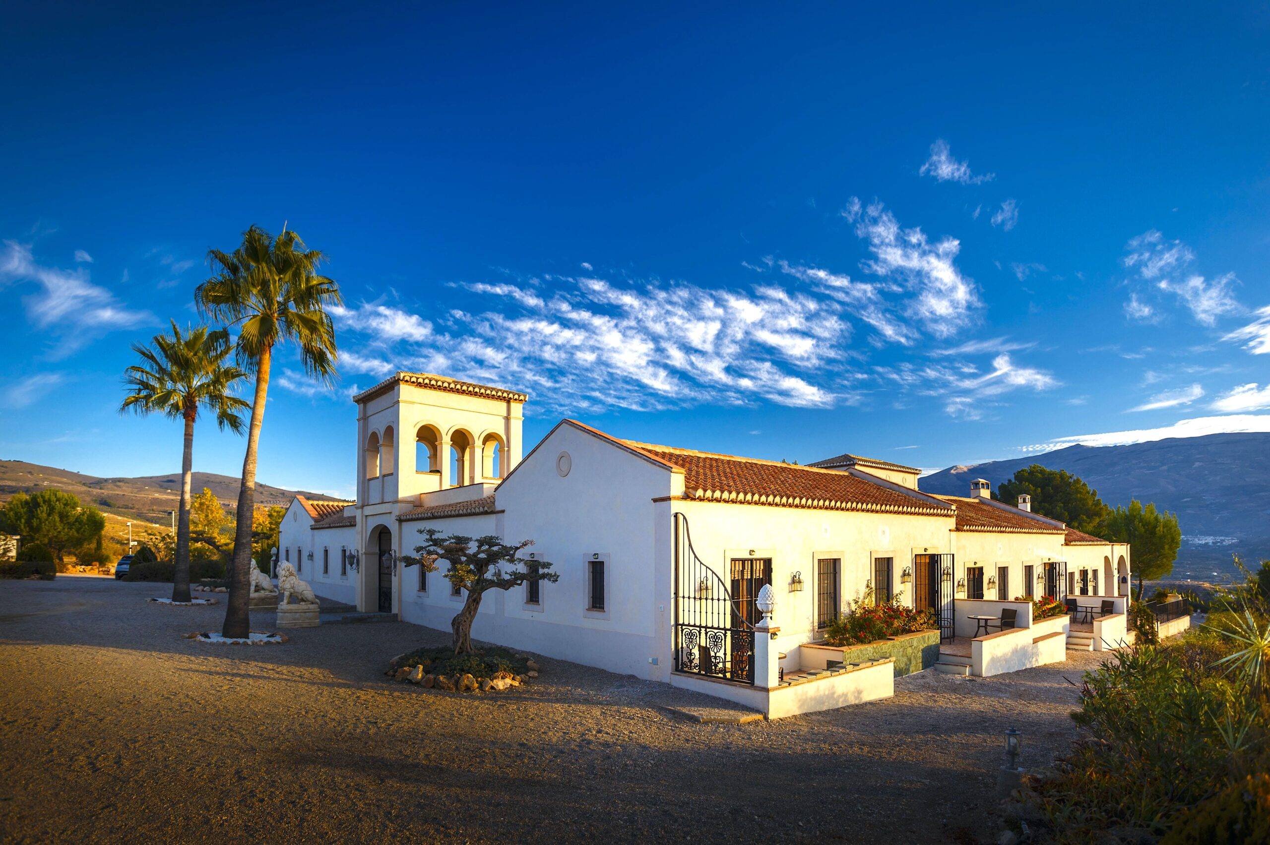 La Esperanza Granada Luxury Hacienda and Private Villa in Andalusia, Spain La Esperanza Granada luxury Spanish hacienda hotel and private villa in Andalusia, Spain, featuring Moorish architecture, palm trees, and panoramic mountain views under a clear blue sky.