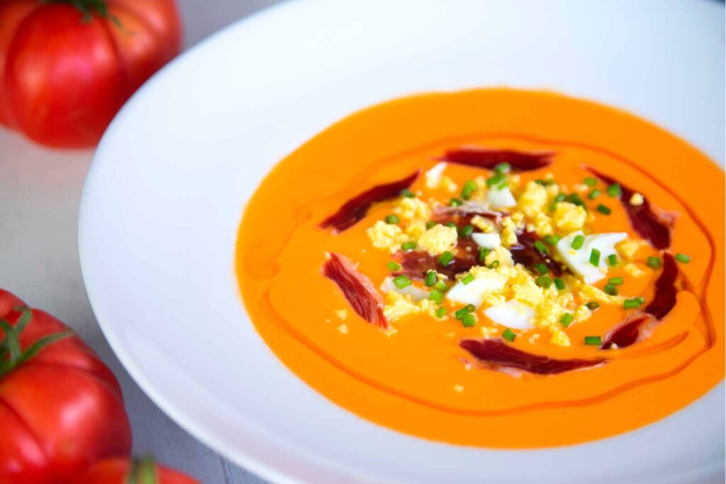 Refreshing cold tomato salmorejo soup served in a bowl, highlighting its smooth texture and vibrant color.